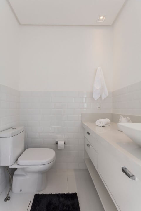 Banheiro com revestimento de tijolinho branco e bacia com caixa acoplada Foto de Idealizzare Arquitetura