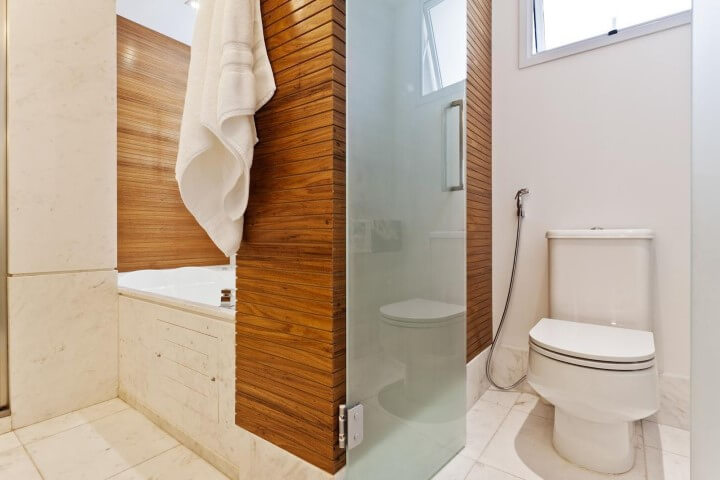 Sala de banho com revestimento de madeira e bacia com caixa acoplada Foto de Sesso e Dalanezi