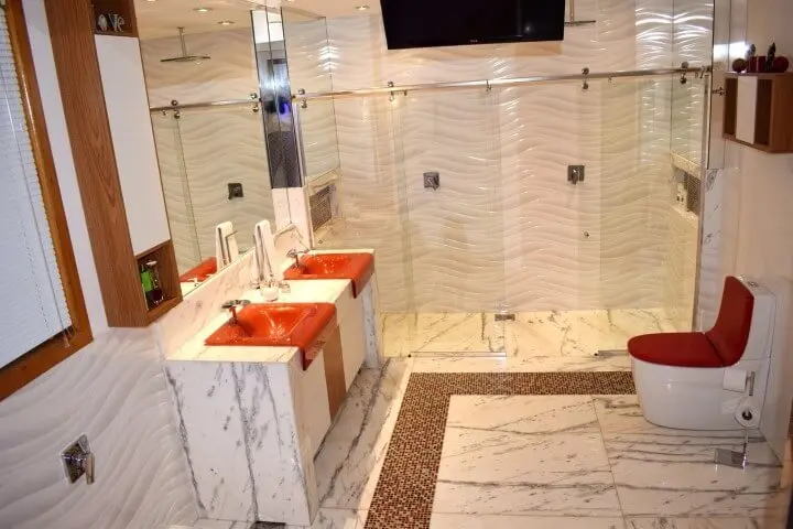 Sala de banho de casal com detalhes vermelhos até mesmo na bacia com caixa acoplada Foto de Studio Perret Arquitetura