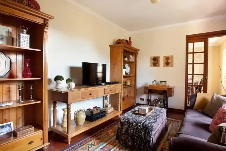 Sala de estar com móveis usados feitos de madeira de demolição Projeto de Liliana Zenaro