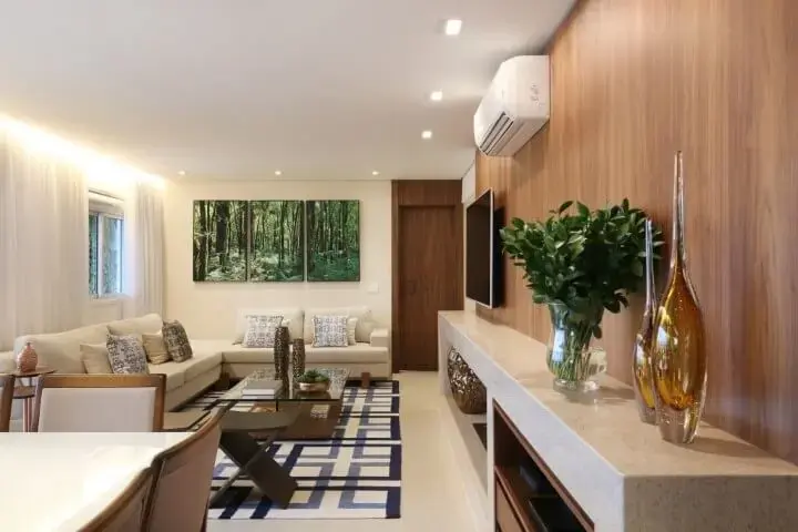 Sala de estar com painel de madeira e rack de granito Projeto de SP Estúdio