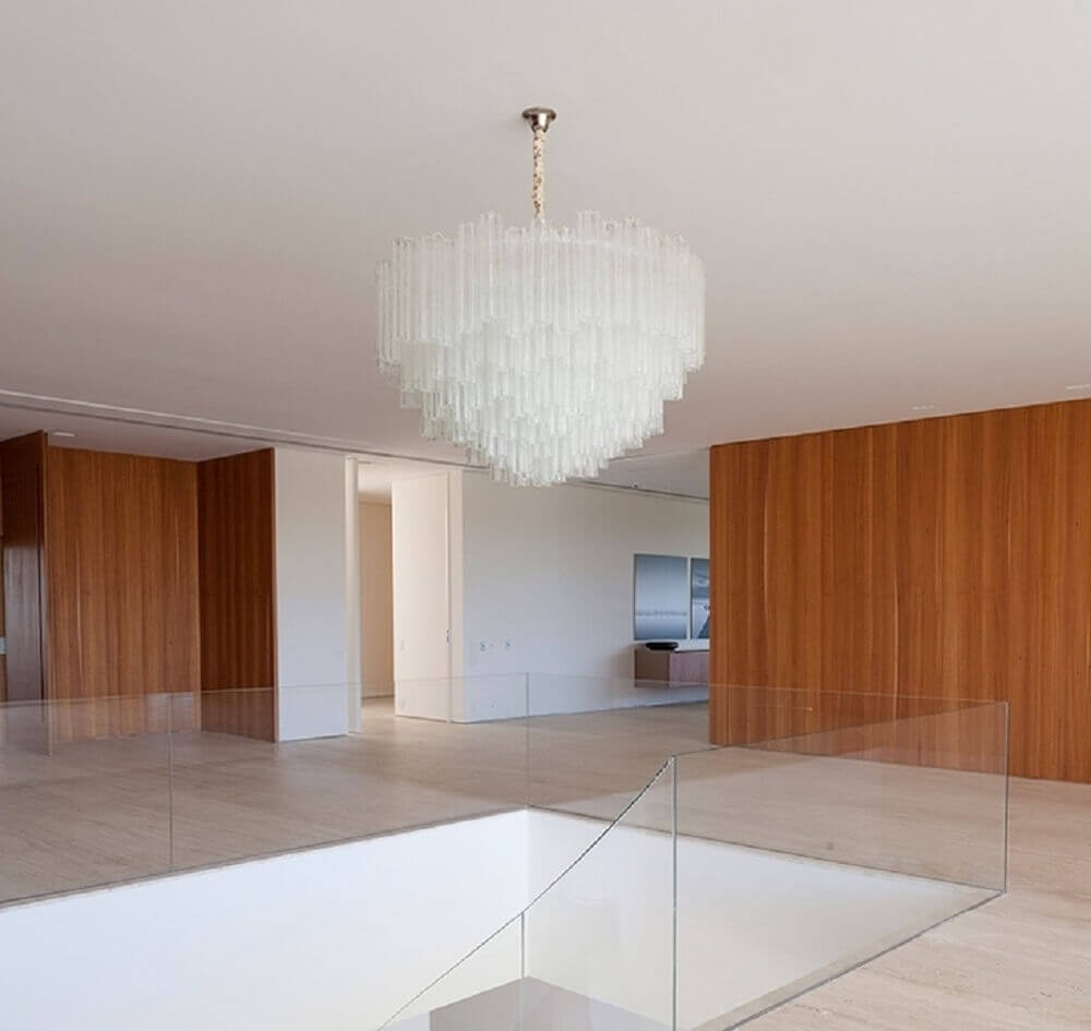 ambiente decorado com guarda corpo de vidro e parede revestida com placas de madeira Foto Roberto Migotto