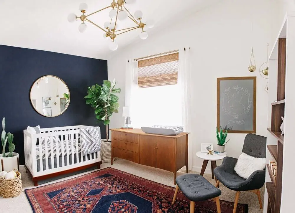 cadeira de amamentação moderna para quarto de bebê com tapete tipo persa e parede azul marinho Foto Project Nursery