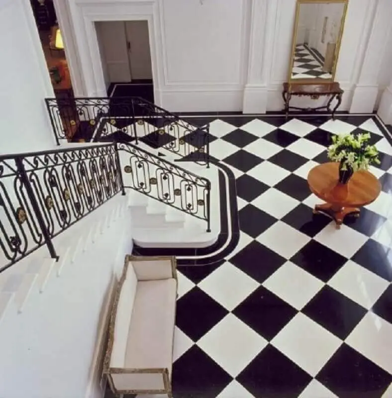 decoração clássica com piso quadriculado preto e branco e guarda corpo de ferro Foto Roberto Migotto