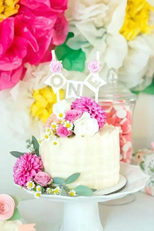 decoração com muitas flores para festa tropical com bolo branco Foto Costinc
