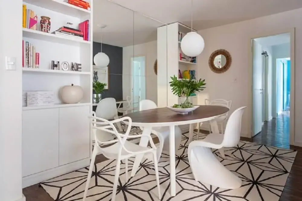 decoração com parede espelhada armário branco e mesa oval com cadeiras modernas para sala de jantar Foto Roberto Robl