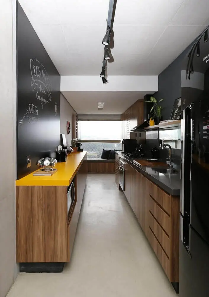 decoração cozinha corredor com parede de giz bancada amarela e armários de madeira Foto SP Estudio