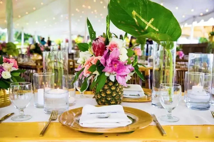 decoração de festa tropical com arranjo de flores feito em abacaxi Foto Internovias