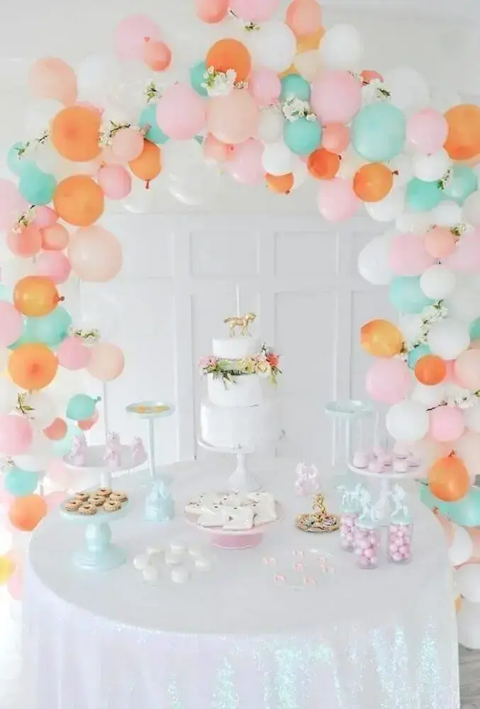 decoração de mesa com balões e bolo branco com arranjo de flores Foto Picture Lights