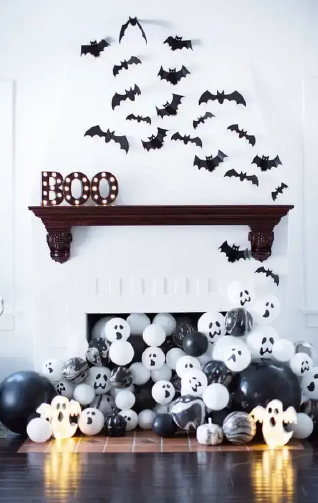 decoração para Halloween com balões saindo da lareira e morcegos na parede Foto MOODecor