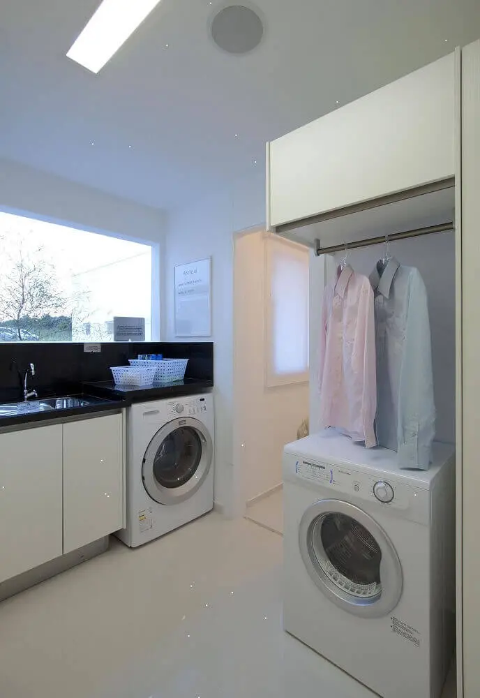 lavanderia planejada com armários brancos e bancada preta Foto Ornare