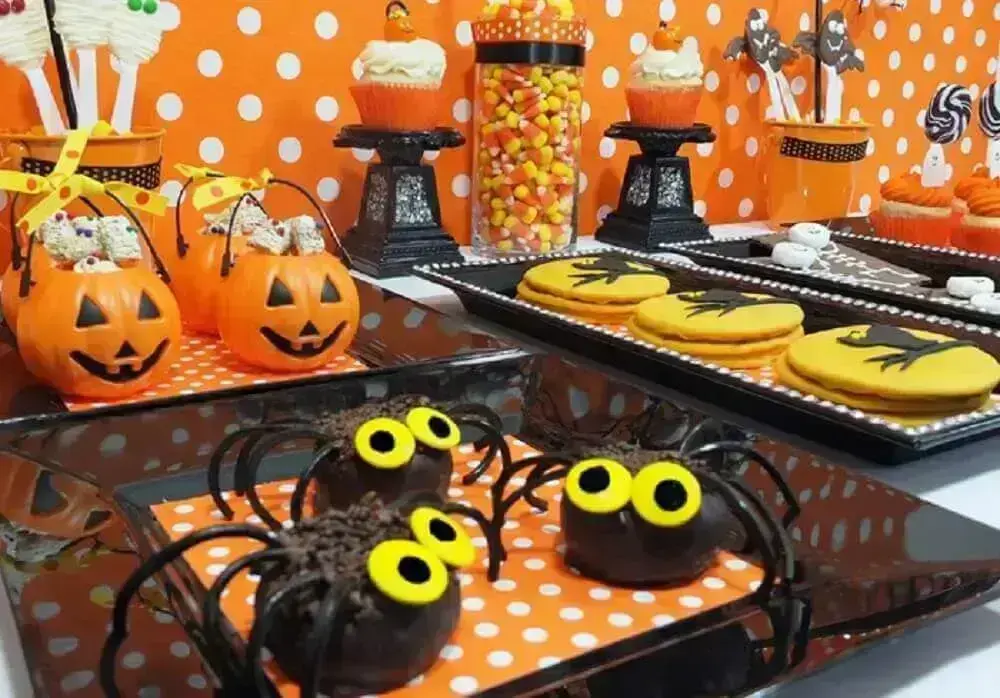 mesa de festa de halloween decorada com docinhos personalizados e potinhos em formato de abóbora Foto Amy Atlas Blog