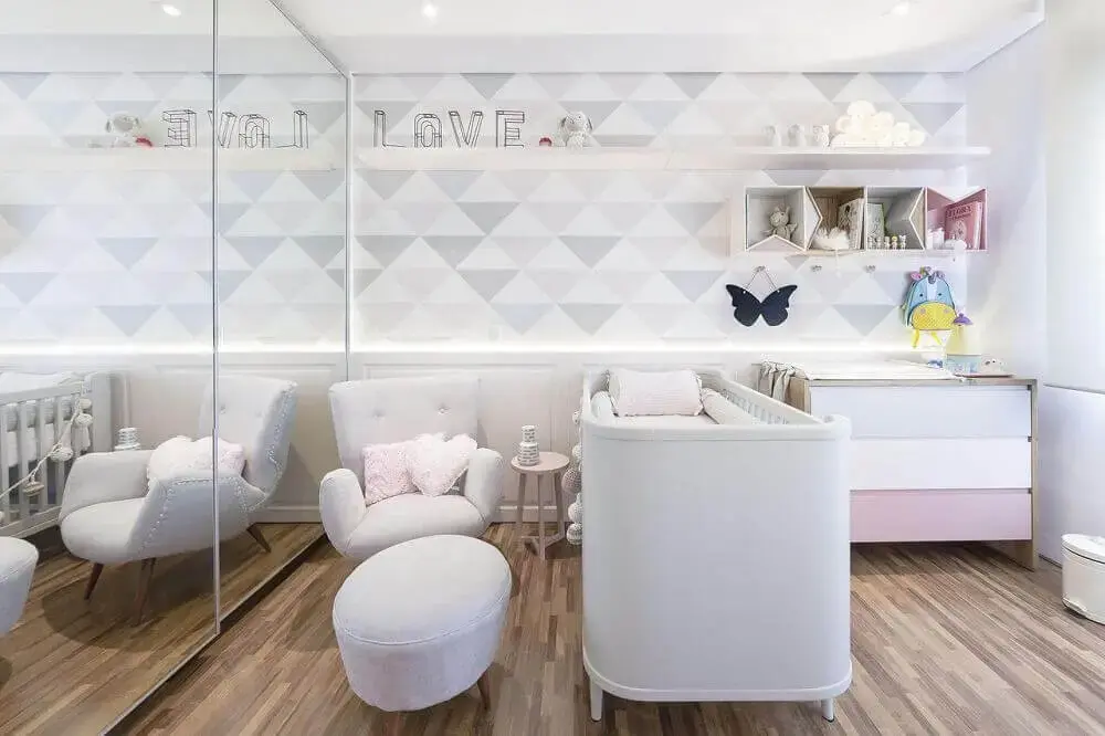 quarto de bebê decorado em tons pastel com papel de parede e cadeira de amamentação moderna com banquinho para colocar os pés Foto Figueiredo Fischer