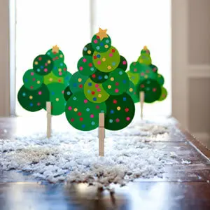 Decoração de artesanato de papel de árvore de natal na mesa de madeira com  borrão de árvore de natal grande atrás.