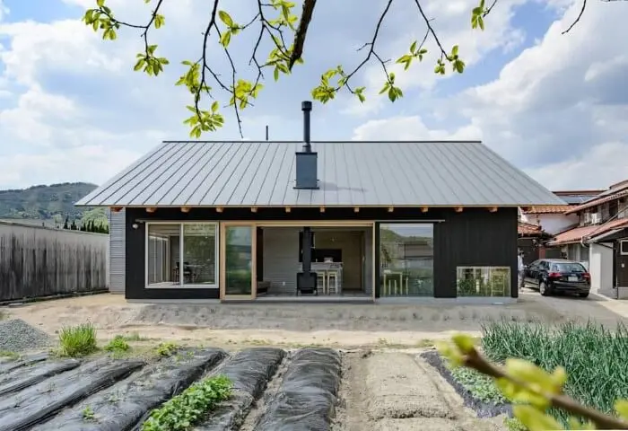 Casas pré-fabricadas de madeira preta com telhado cinza