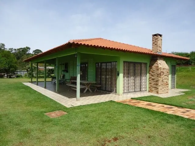 Casas pré-fabricadas térrea verde com chaminé