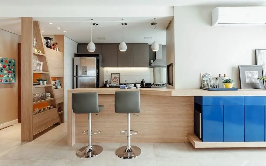 Cozinha integrada com balcão de madeira