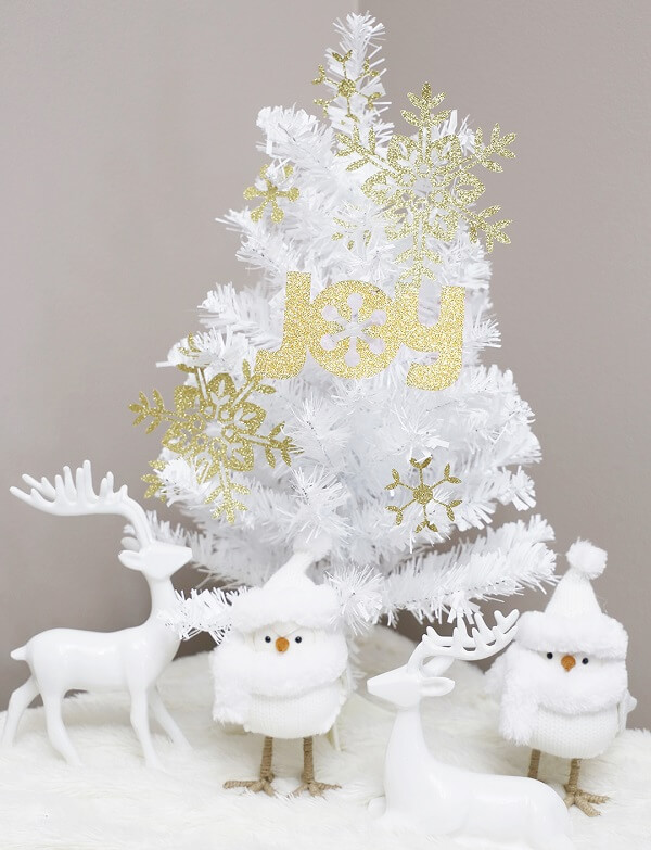 Detalhes em dourado se destacam nessa árvore de Natal branca