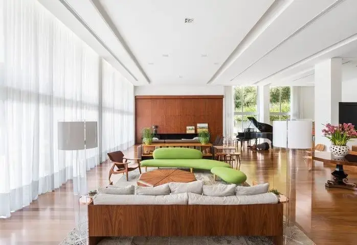 Decoração de sala ampla com sofá discreto e chaise verde Projeto de Leonardo Muller