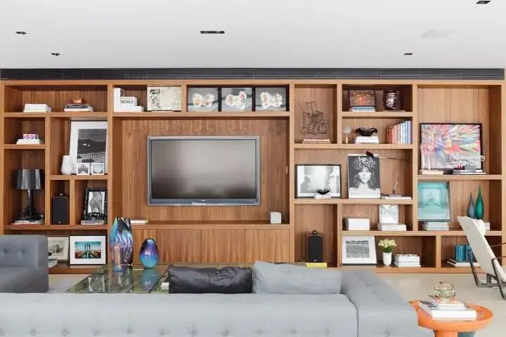 Decoração de sala com estante de madeira cheia de objetos de decoração Projeto de Suite Arquitetos