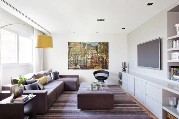 Decoração de sala com sofá com chaise e pufe amplo usado como mesa de centro Projeto de Suite Arquitetos