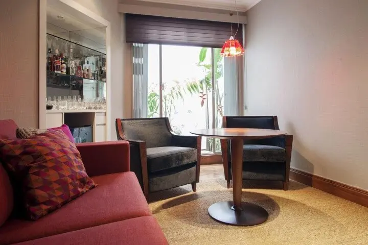 Decoração de sala com sofá vermelho e poltronas pretas Projeto de Deborah Basso