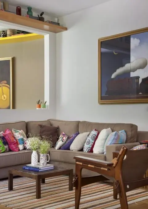 Decoração de sala de estar com sofá marrom e almofadas coloridas Projeto de Artis Design