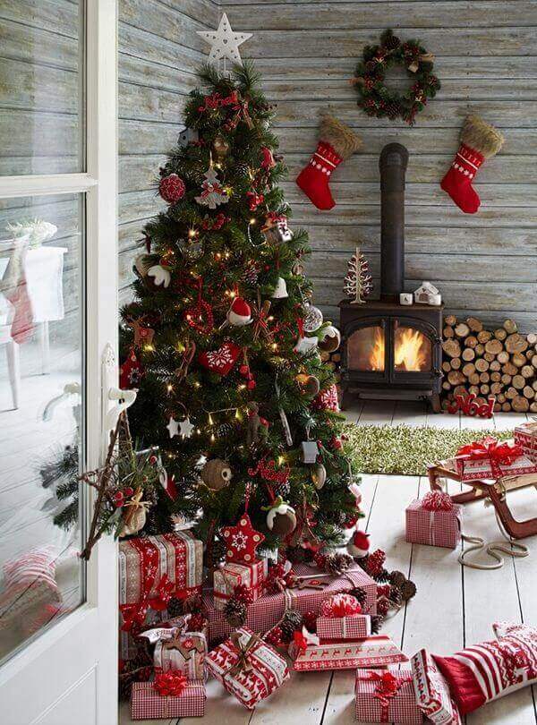 Pinheiro de natal em sala de estar decorada com motivos natalinos