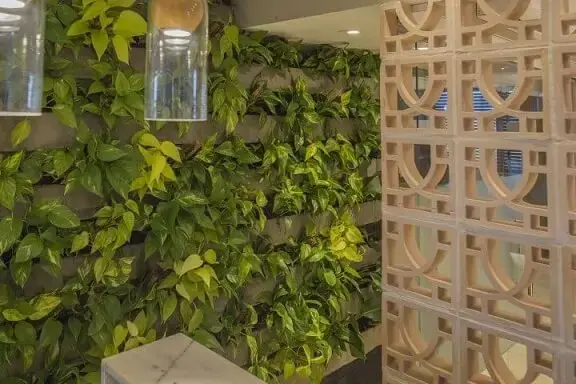 Recepção de escritório com jardim vertical com blocos pré-moldados Projeto de Galpão Design Arquitetura