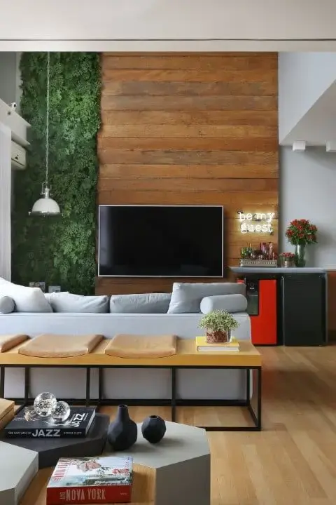 Sala de estar com pé direito alto e jardim vertical e painel de madeira Projeto de Estúdio AE