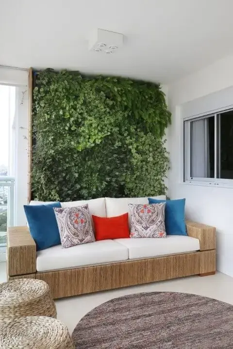Varanda gourmet com jardim vertical atrás do sofá Projeto de SP Estúdio