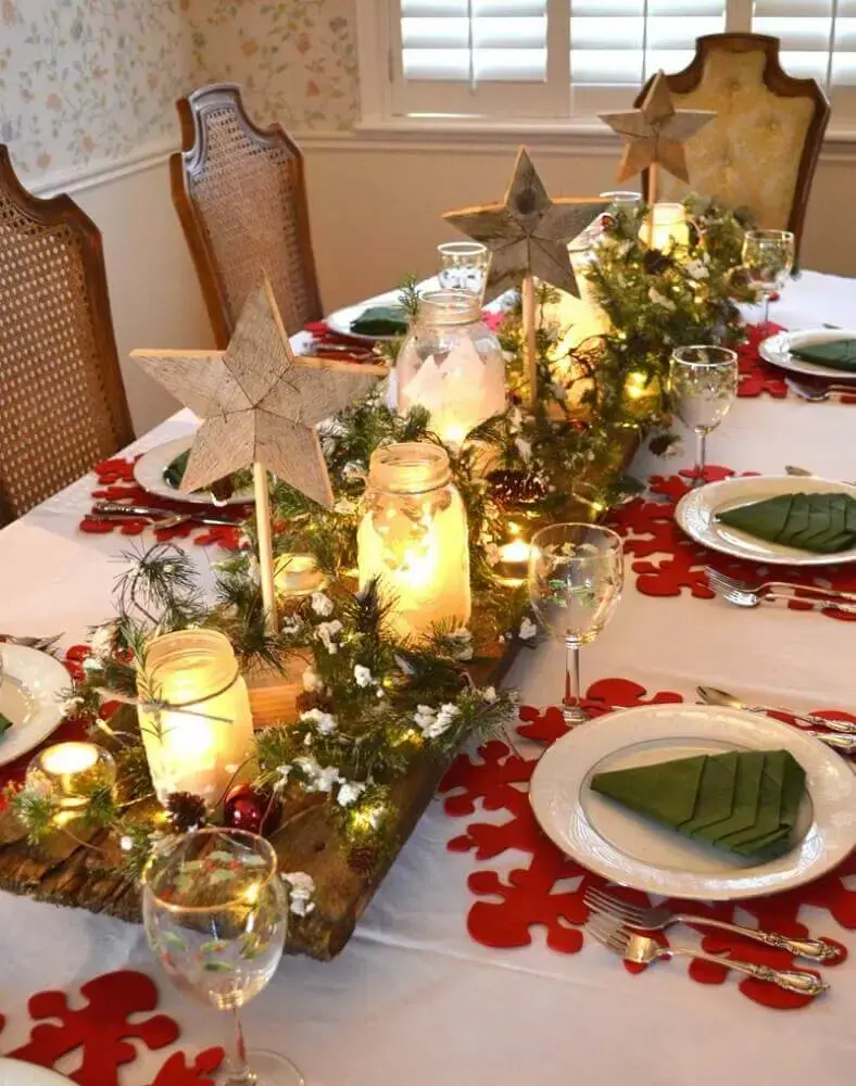 arranjos de natal com velas para decoração de mesa com suporte de madeira ramos de plantas e bolas vermelhas Foto Apsip