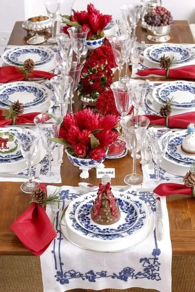 arranjos de natal para mesa decorada com louça azul e branca e flores vermelhas Foto Fashion Submarine