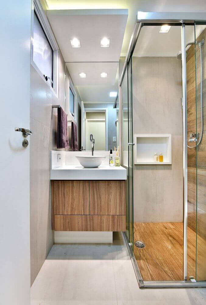 banheiro pequeno planejado decorado com revestimento que imita madeira Foto Tetriz Arquitetura