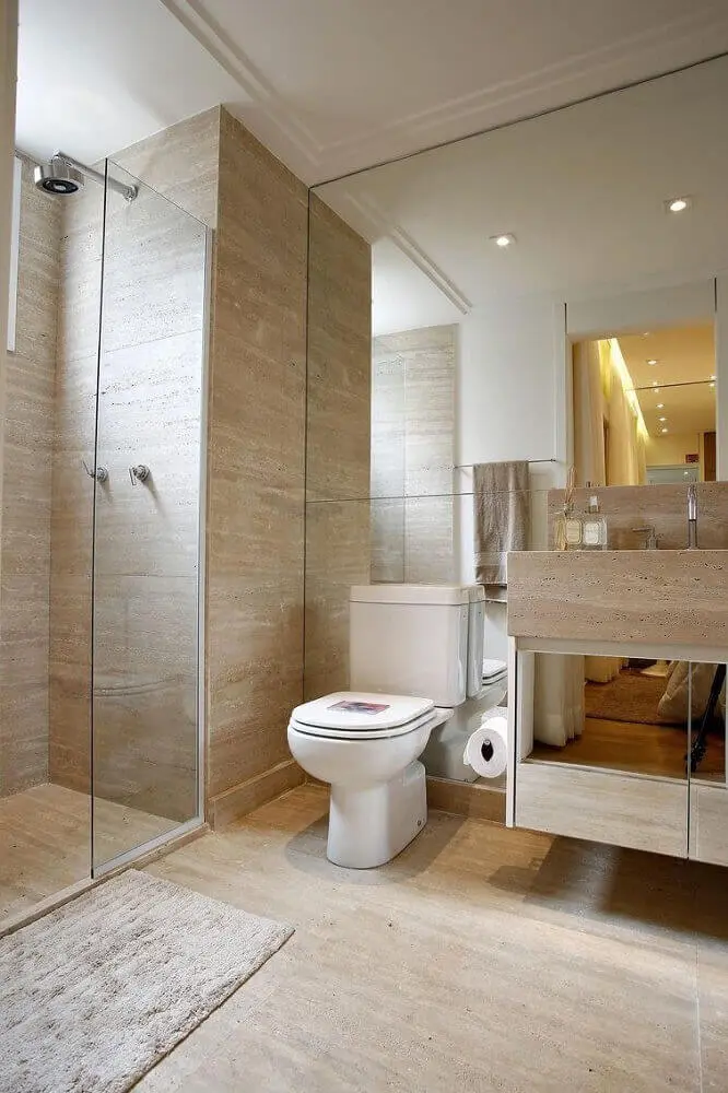 banheiro planejado com revestimento que imita madeira e armário espelhado Foto BY Arq&Design