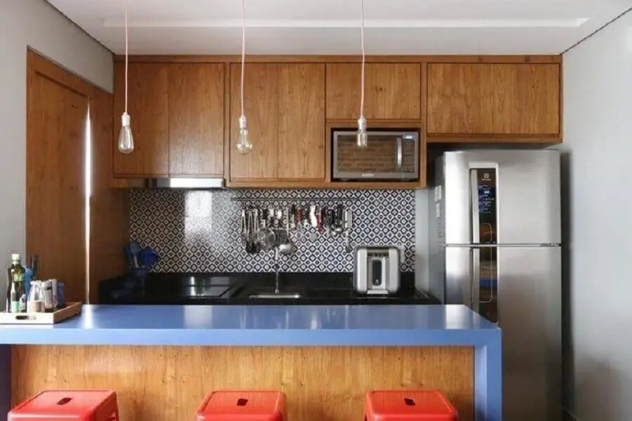 cozinha planejada pequena com balcão azul e armários de madeira Foto GF Projetos