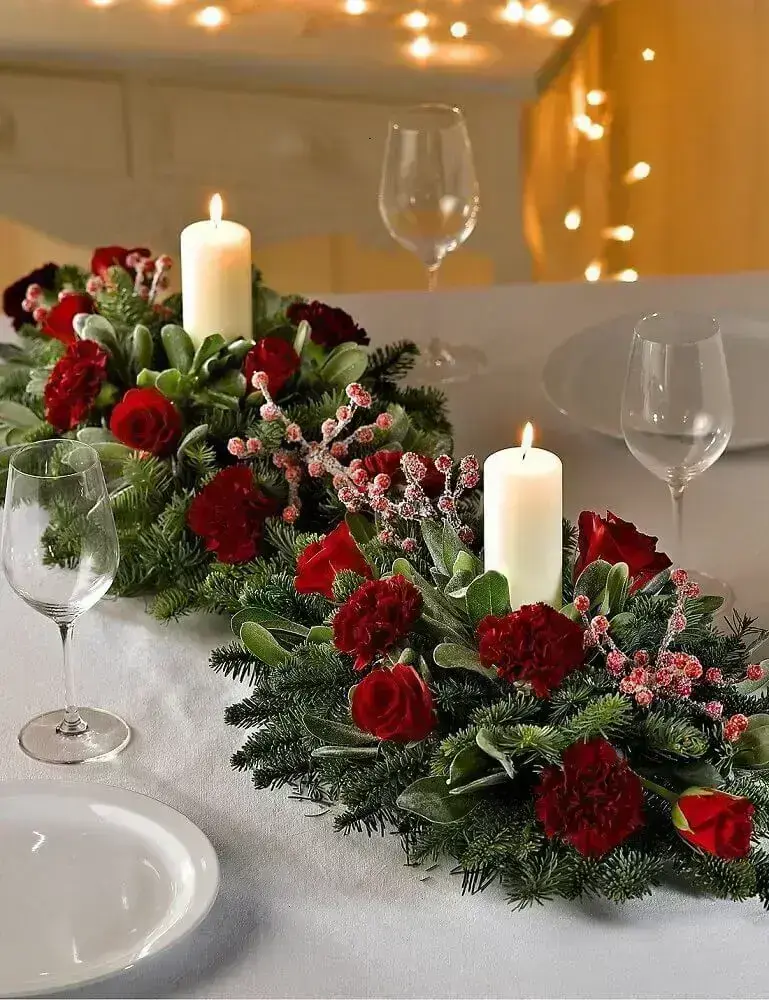 decoração com arranjos de natal com velas e rosas vermelhas Foto Marks & Spencer