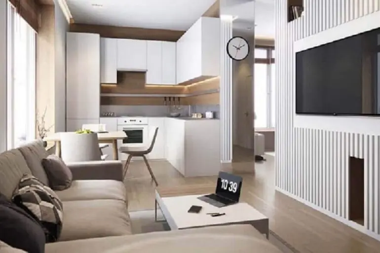 decoração em tons neutros com cozinha planejada integrada com sala de TV