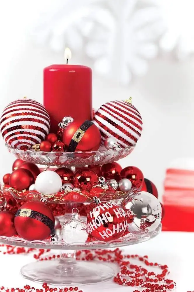 decoração natalina com arranjos de bolas e velas vermelhas Foto Artecht