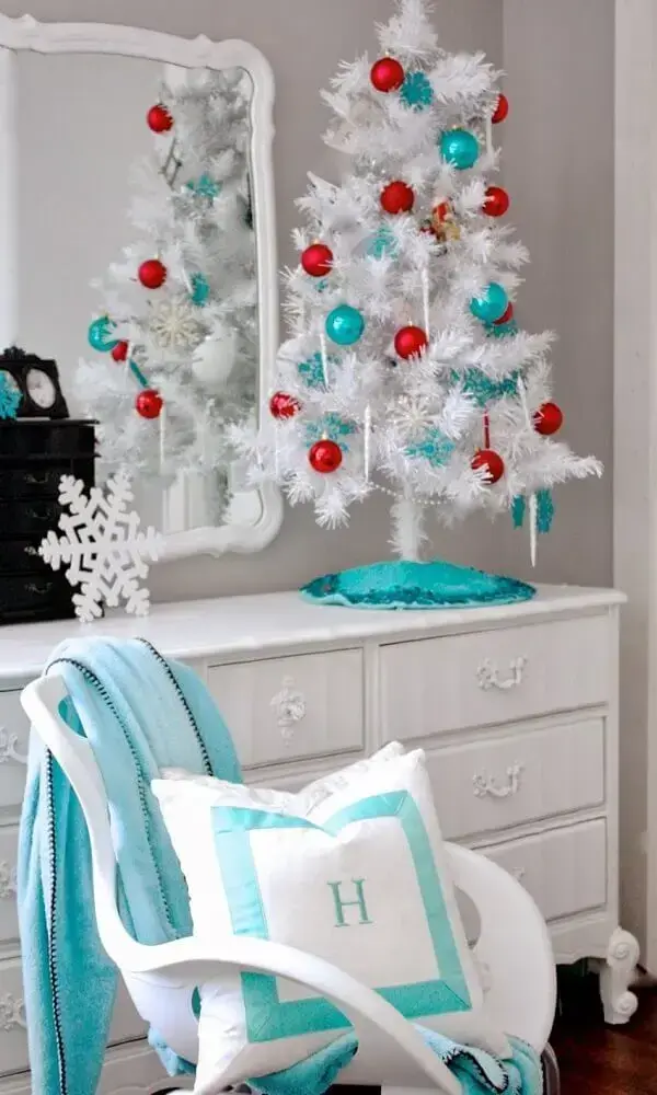 decoração para quarto com árvore de natal branca pequena com bolas vermelhas e azuis Foto Golbis