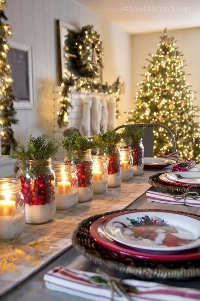 mesa de natal simples e rústica decorada com recipientes de vidro com velas e plantas Foto Seelenflügel