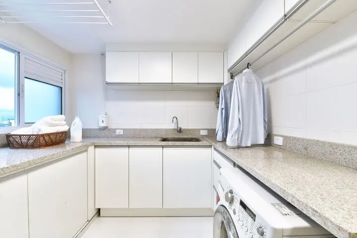Área de serviço planejada com armário superior e cabideiro de roupas Projeto de Tetriz Arquitetura