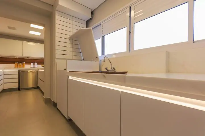Área de serviço planejada com máquina de lavar escondida em armário Projeto de Enzo Sobocinski