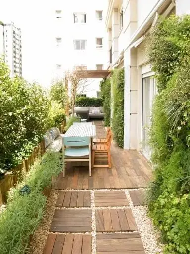 Área externa com jardim vertical em todas as paredes Projeto de Gigi Botelho