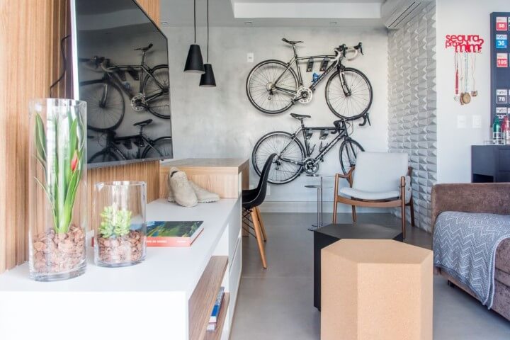Apartamento pequeno decorado com bicicletas suspensas na sala de estar Projeto de Danyela Correa