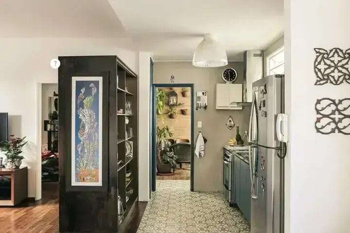 Apartamento pequeno decorado com cozinha integrada à sala com uma estante de madeira Projeto de Casa Aberta
