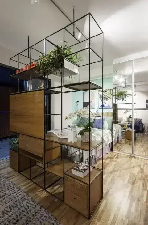 Apartamento pequeno decorado com estante modular separando o quarto da sala Projeto de Decoradoria Decoração Online