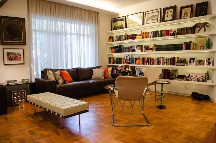 Biblioteca com sofá de couro e piso de taco Projeto de Adriana Fornazari