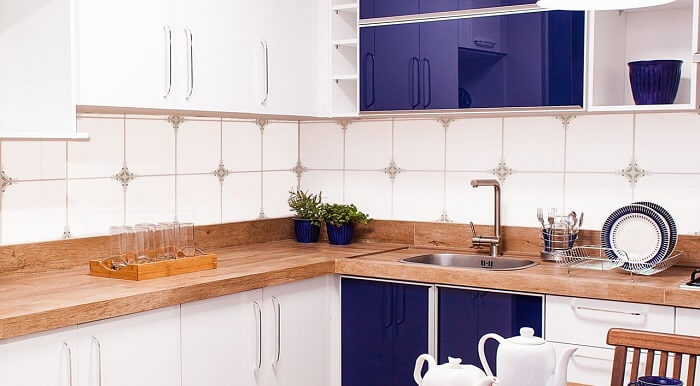 Cozinha azul com bancada de madeira rústica