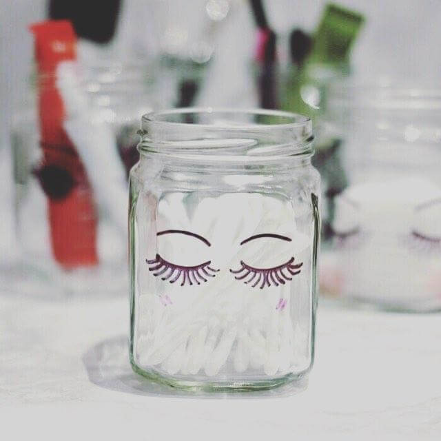 Potes de vidro com cotonetes e desenho de olhos no vidro Foto de Apto 108